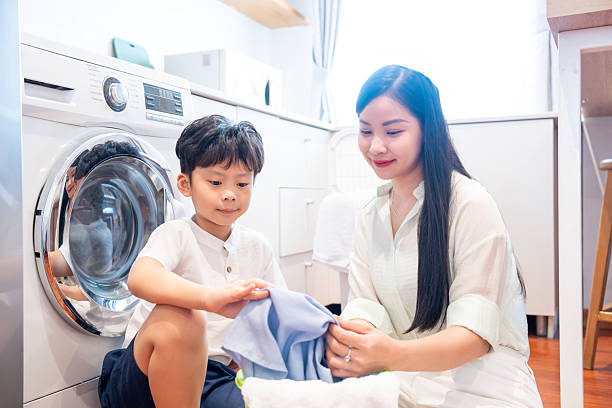 istock A young boy helps his mother fold laundry in their bright modern laundry room with appliances 2220700161