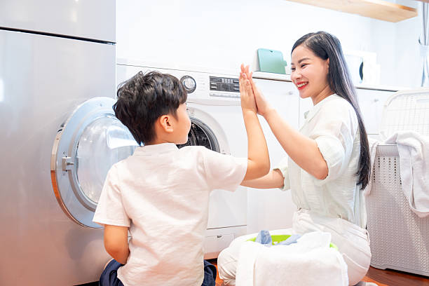 istock A mother and son celebrate completing their laundry responsibilities with a joyous high five 2220700961