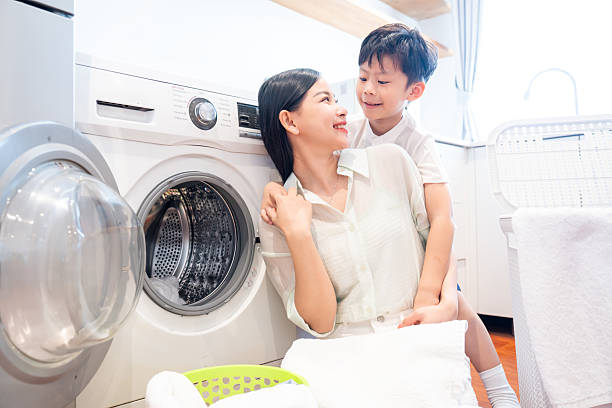 istock Mother and son share a tender moment near the washing machine while doing laundry together 2220701024