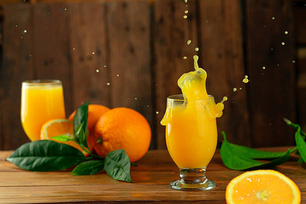 istock Fresh orange juice splash on wooden surface. 2220701619