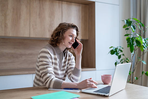 istock Interested woman freelancer managing work phone calls, digital tasks with laptop from home workplace 2220702282