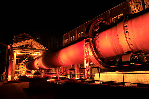 idle cement plant rotary kiln machinery at night, closeup of photo