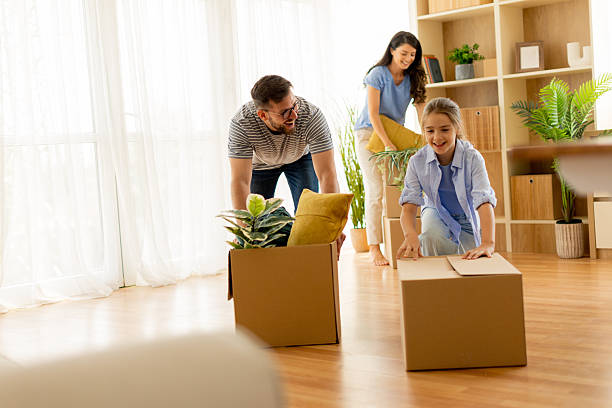 istock Family enjoys unpacking boxes while moving into their new home, filled with laughter and joy in the bright living room 2220712561