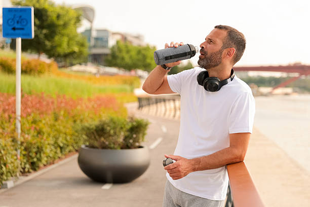 istock Enjoying a refreshing drink while taking a break during a morning jog at the riverside pathway 2220712671