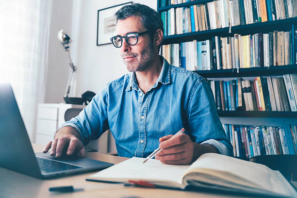 istock smiling man working at laptop at desk 2220714443