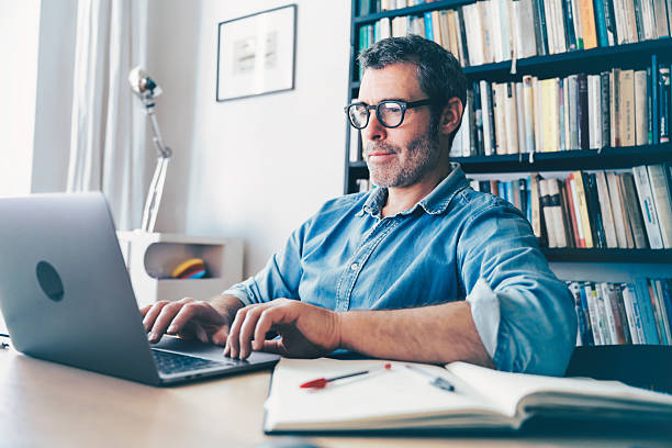 istock smiling man working at laptop at desk 2220714467