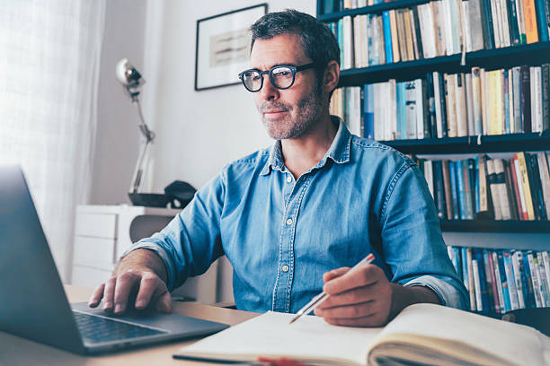 istock smiling man working at laptop at desk 2220714491
