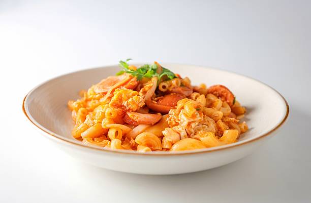 istock Stir fried macaroni with tomato sauce ,sausage and egg in white plate on white background 2220714513