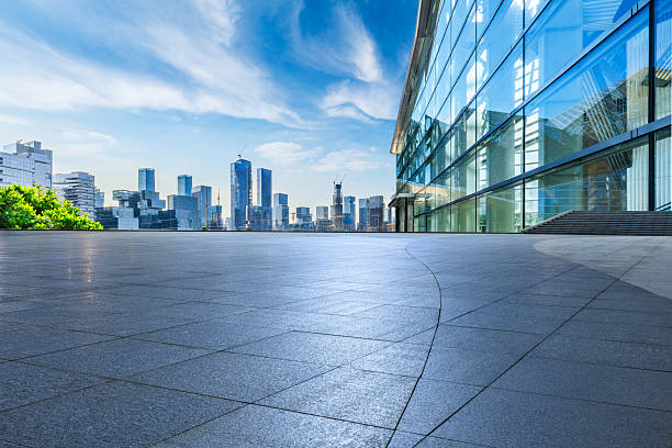 istock Empty square floor and modern glass office building with city skyline under blue sky 2220716080