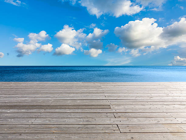 istock Empty wooden boardwalk floor and blue sea with beautiful sky clouds on a sunny day 2220716082