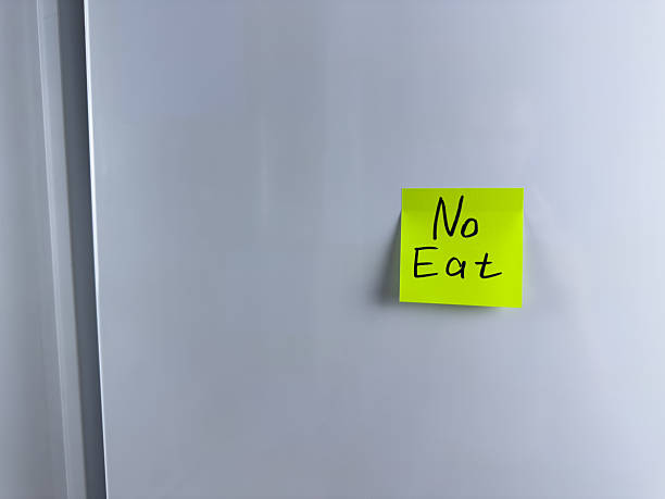 istock No eat. Reminder on refrigerator prohibiting eating 2220717053