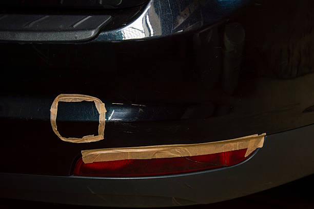 istock The vehicle's rear bumper shows a sectional damage highlighted by masking tape, preparing for a car polishing and repair session 2220720723