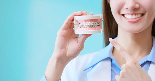 istock Dentist smile holding braces model 2220723300