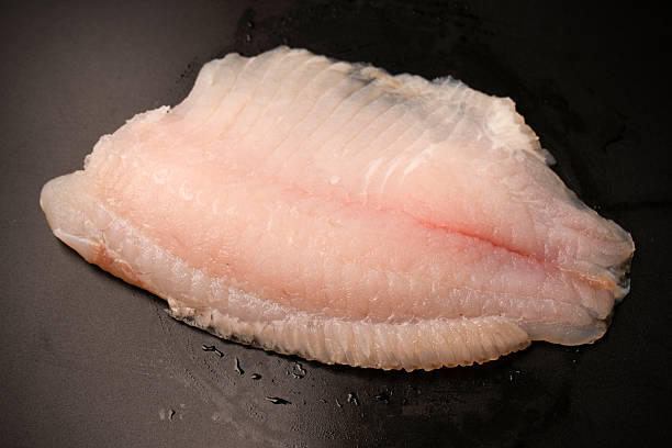 istock Fresh tilapia fillet on black background, top view. 2220725929