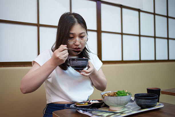 An Asian woman enjoying Japanese food alone