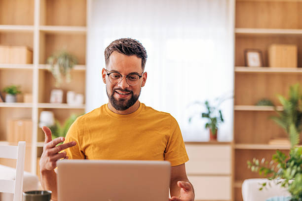 istock Young man working from home having a video call on his laptop 2220730106