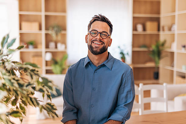 istock Young businessman smiling and looking at camera in modern office 2220730676