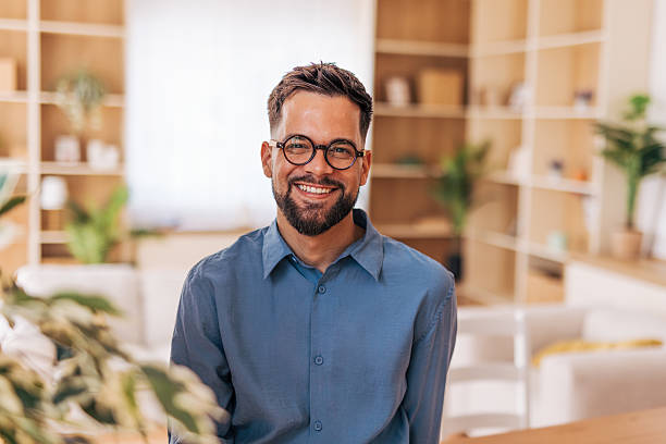 istock Young businessman smiling and looking at camera in modern office 2220730926