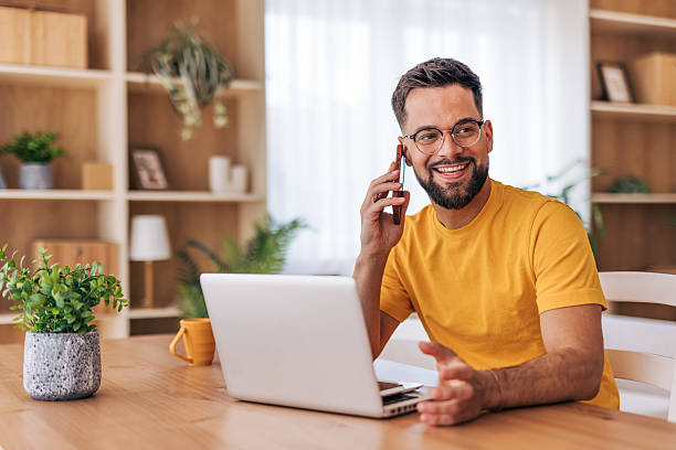 istock Young man working from home and talking on phone 2220731724