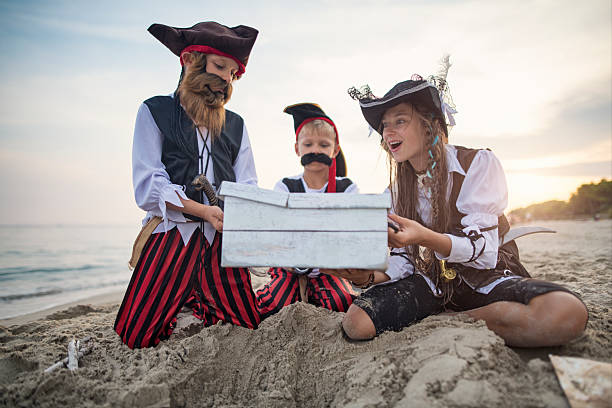 istock Pirate crew unearthing treasure together at sunset on a sandy beach 2220731849