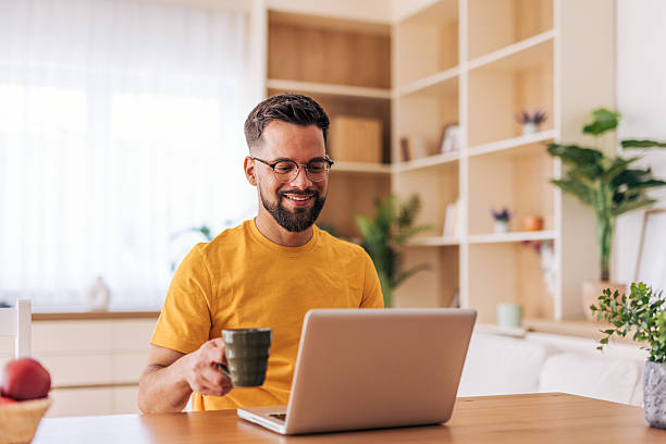 istock Young man working from home, enjoying a cup of coffee 2220732106
