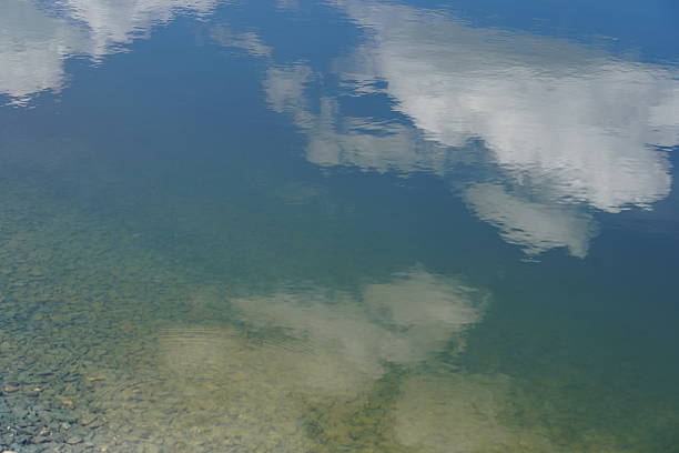 istock An artificial pond with water high in the mountains. Coniferous trees and clouds are reflected in the pond. The lake reflects nature. 2220732286