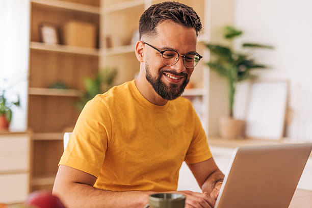 istock Young man working from home on laptop and smiling 2220732369