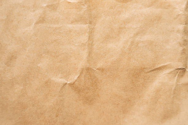 istock Wrinkled brown kraft paper texture, neutral background for eco-friendly packaging or graphic overlays. 2220734257