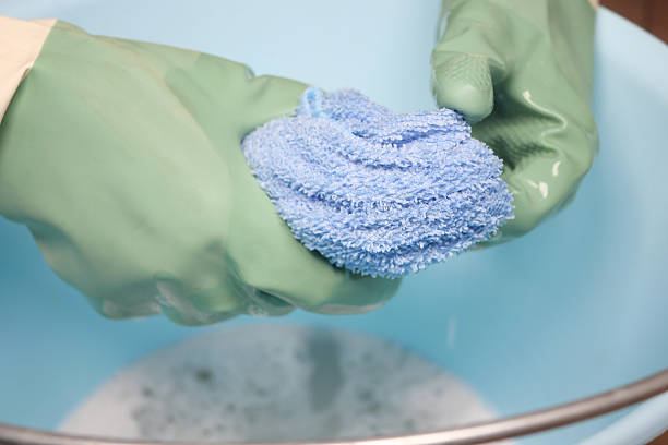 istock Person cleaning a blue cloth in a basin at home 2220735699