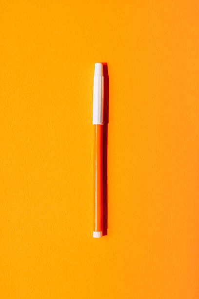 istock Bright orange marker with white cap centered on a vivid orange background, minimal back to school pop art concept. 2220735726