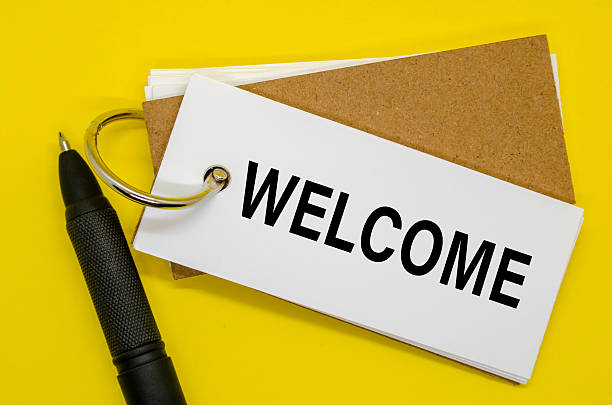 istock Open notebook with WELCOME sign on the front, upright pen beside it 2220738923