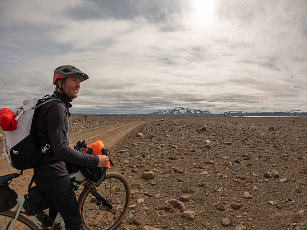 istock Cyclist Taking a Break on Rocky Desert Road 2220739697