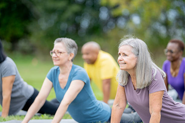 istock Group of Seniors Practicing Yoga Outdoors in a Green Park Setting 2220739887