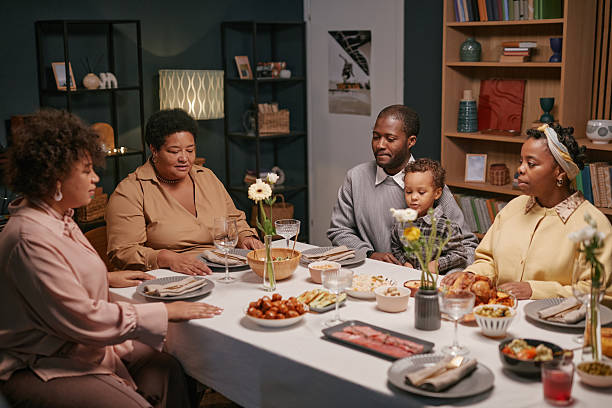 istock Black Family Enjoying Meal Together at Cozy Dining Table 2220740247