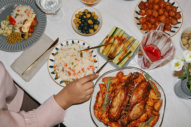 istock Woman Sitting at Dining Table with International Cuisine and Drinks 2220740258