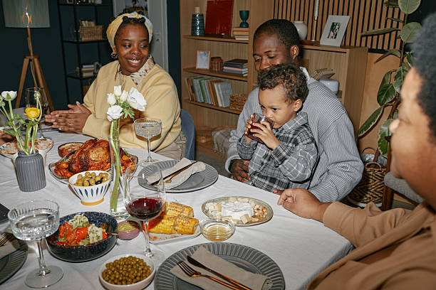istock Black Family Enjoying Dinner with Young Child around Dining Table at Home 2220740384