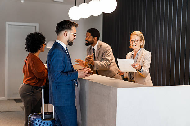istock Businessman checking in at hotel reception desk 2220740478