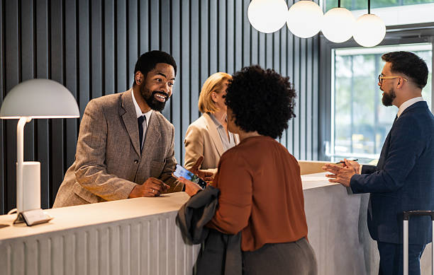 istock Hotel receptionist assisting guests at check-in counter 2220741106