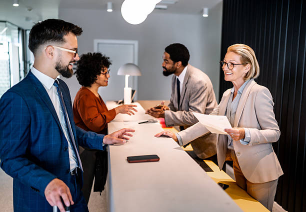 istock Businesspeople checking in at hotel reception desk 2220741530