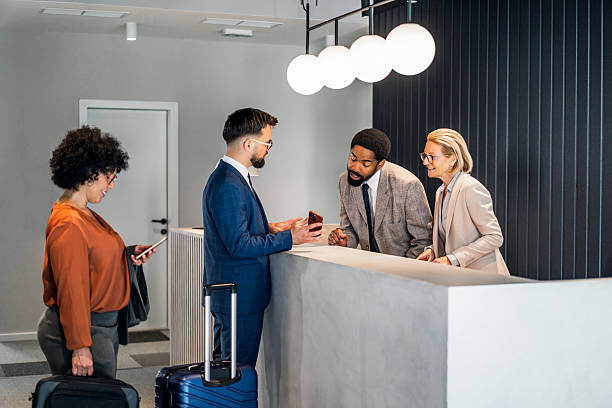 istock Businessman showing smartphone to hotel receptionists at check in 2220741671