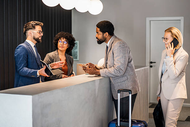 istock Businesspeople discussing at hotel reception desk 2220741677