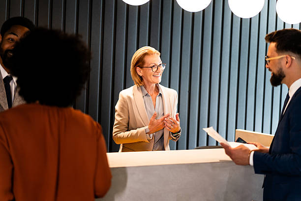 istock Friendly hotel receptionist welcoming business people 2220742005