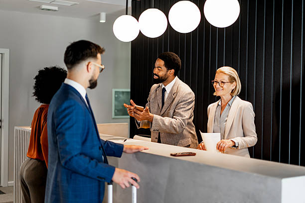 istock Businessman checking in at hotel reception talking to receptionists 2220742880