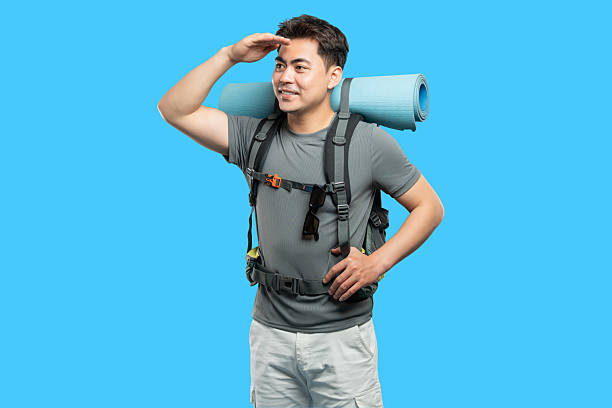 istock Focused backpacker gazes into the distance with hand shielding eyes ready for adventure 2220743159