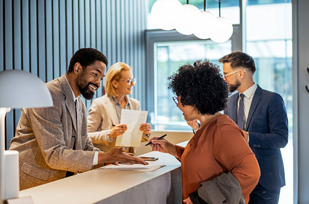 istock Polite hotel receptionist helping guests with check-in process 2220744625