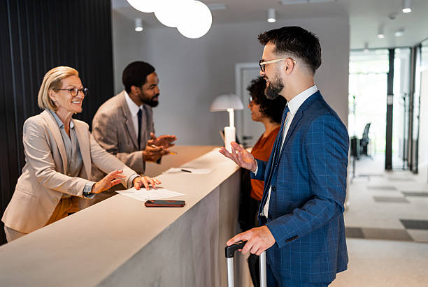 Businessman checking in at hotel reception desk with luggage