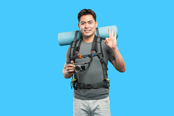 istock Smiling backpacker with camera giving okay hand sign Adventure ready everything is alright 2220746792