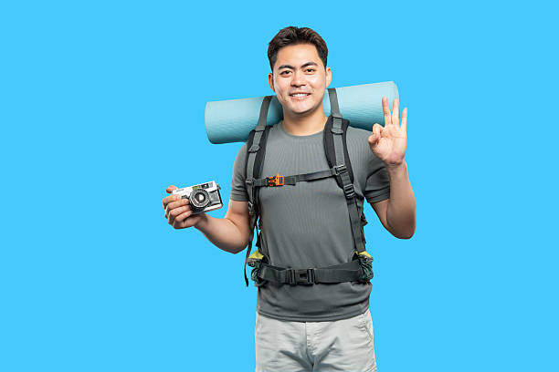 istock Hiker with Backpack Camera and OK Sign: Ready for adventure and capturing scenic moments 2220746848
