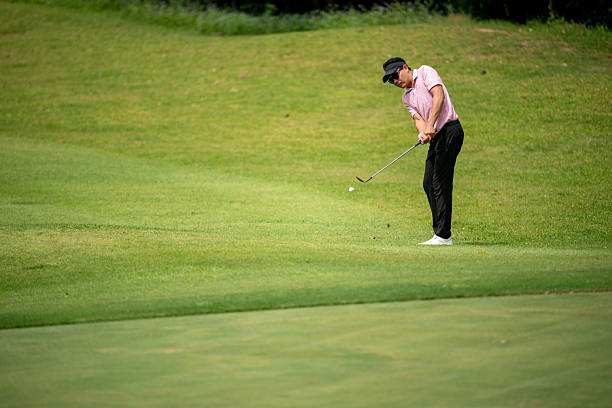istock A man in a pink shirt is playing golf 2220750201
