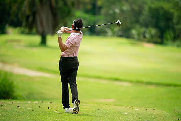 istock A man is swinging a golf club on a green course 2220750203
